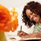 Black Woman Smiling and Writing