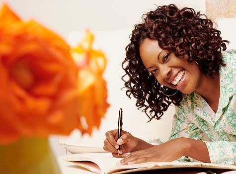 Black Woman Smiling and Writing