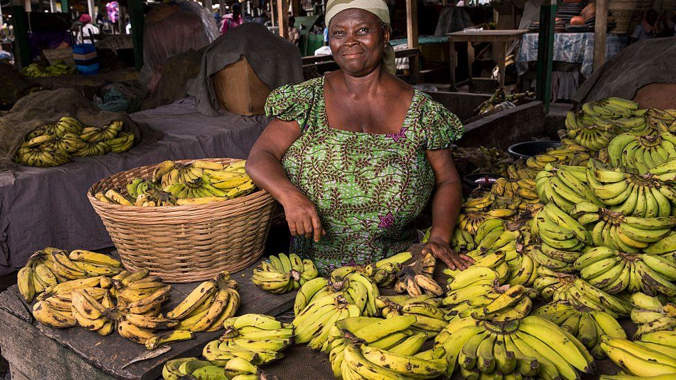 old lady selling bananas happily